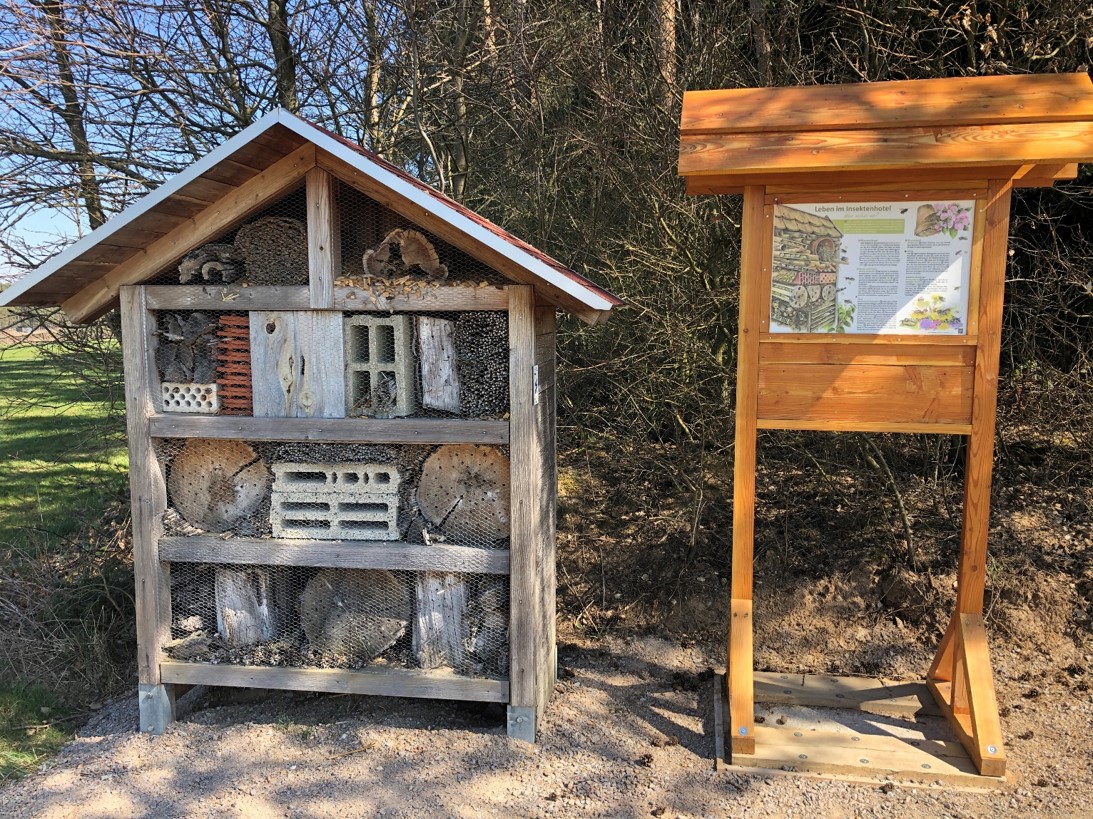 Zeigt Insektenhotel mit Infotafel