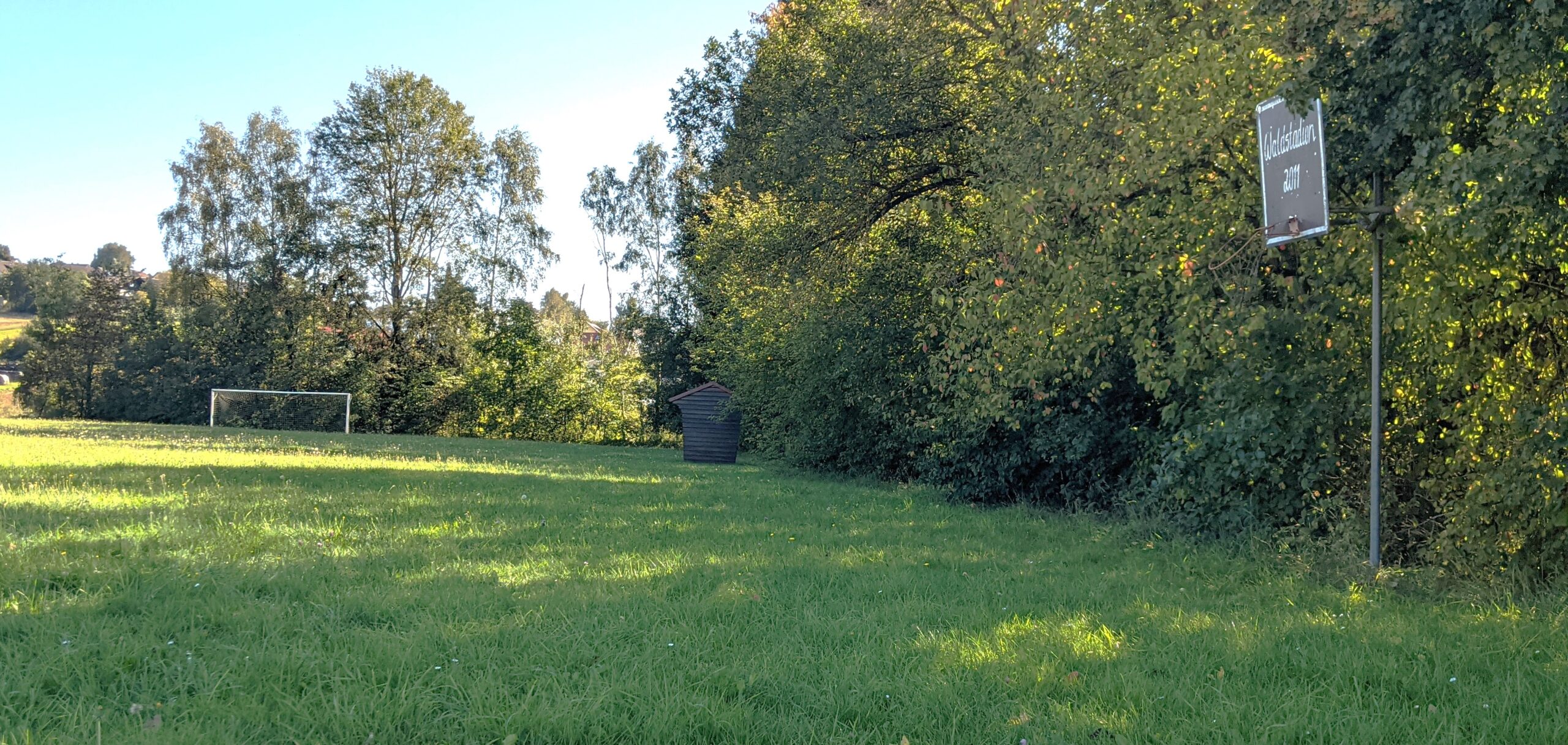 Zeigt eine Wiese mit Toren und Häuschen